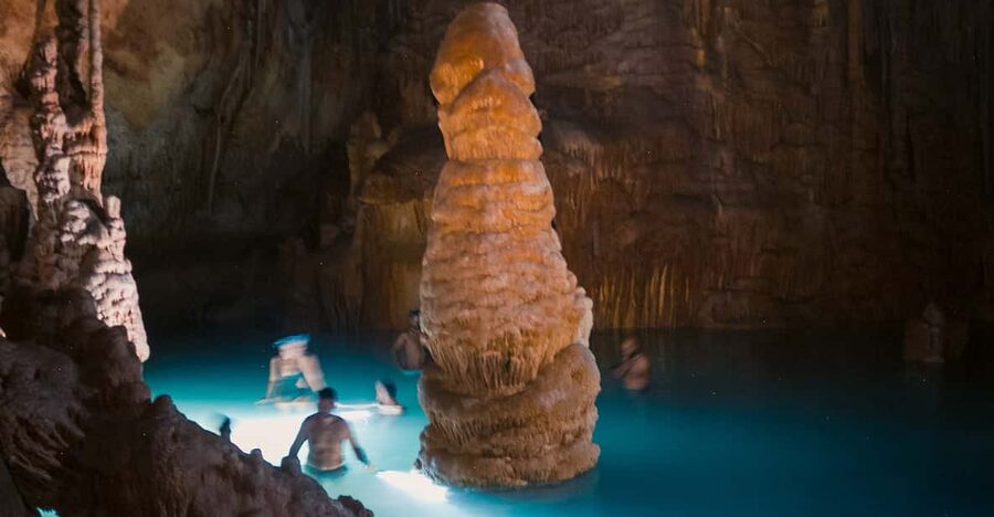 Mallorca: Cala Romántica Cliff Hike and Sea Cave Tour - Reaching the lonely cove: getting kitted up for the swim